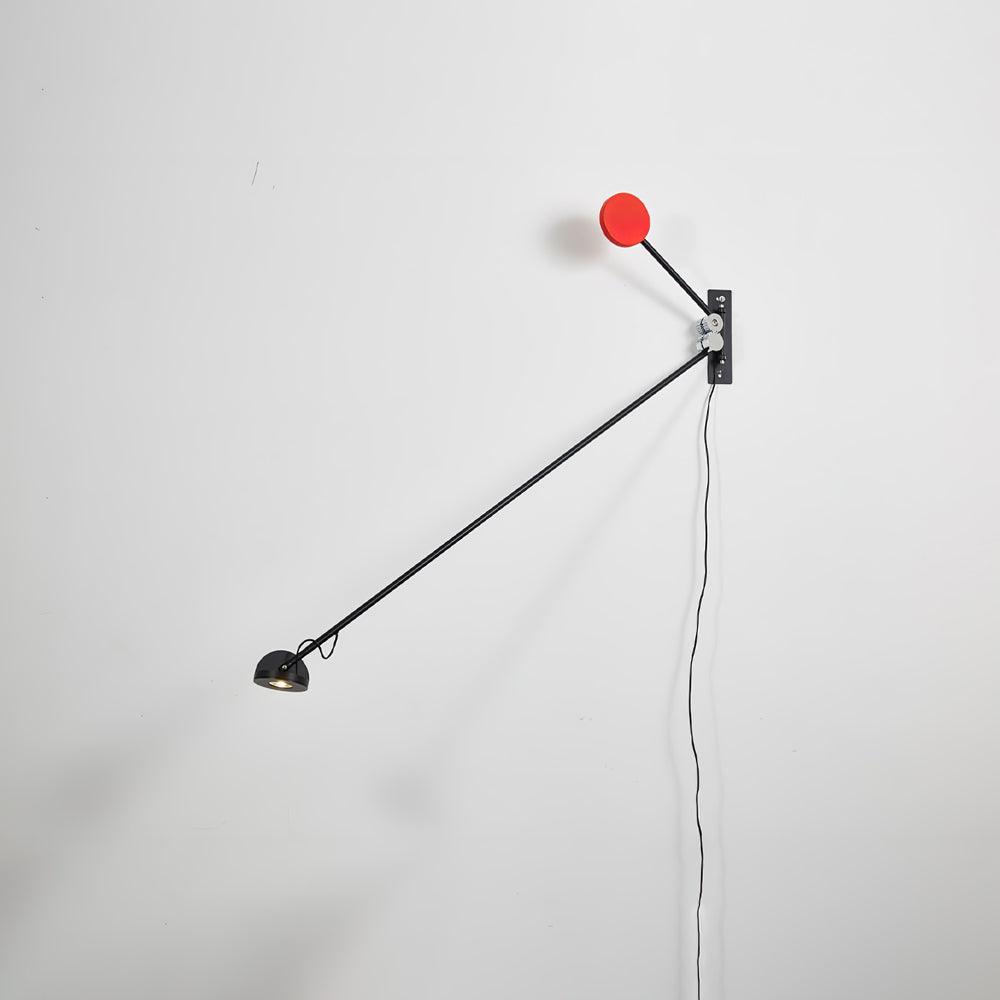 Clérachic wall light with its arm pointing steeply down, a red counterweight above the mount and the cable hanging against a white wall.
