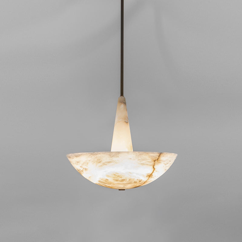 Pale honey Clérachic Cove alabaster pendant on a slim dark rod, the stone warming softly from within against a grey wall