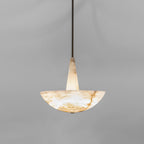 Pale honey Clérachic Cove alabaster pendant on a slim dark rod, the stone warming softly from within against a grey wall
