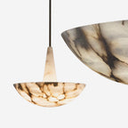 Two Clérachic Cove alabaster bowls on white, the smaller honey-veined fixture beside the larger grey-veined bowl for scale