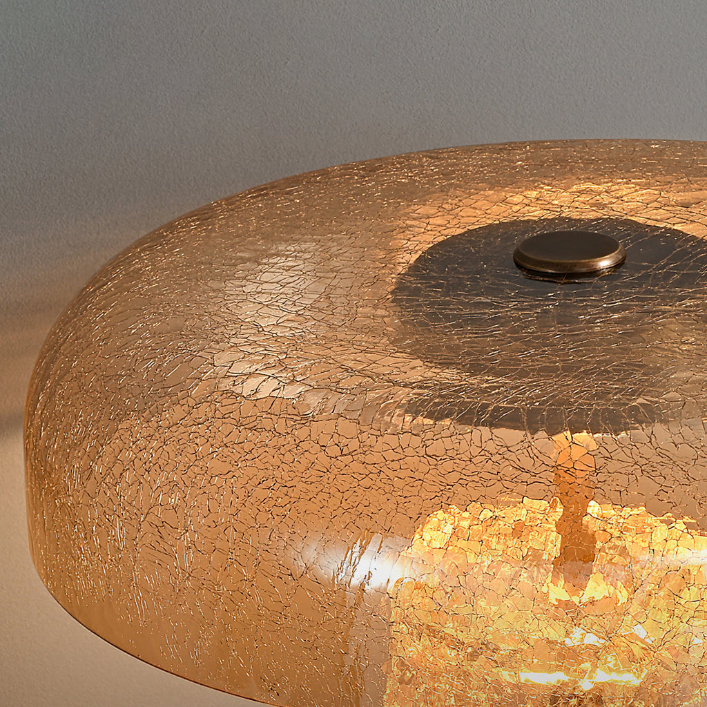 Close view of the amber crackle-glass dome on this Clérachic table lamp, with a small bronze cap on top and light inside.