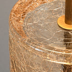 Close view of the crackle-textured glass rim and inner disc, with a bronze plate and stem, on this Clérachic table lamp.