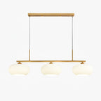 Clérachic cream glass 3-light cluster, gold canopy and bar, three lit pebble shades on a clean white backdrop.
