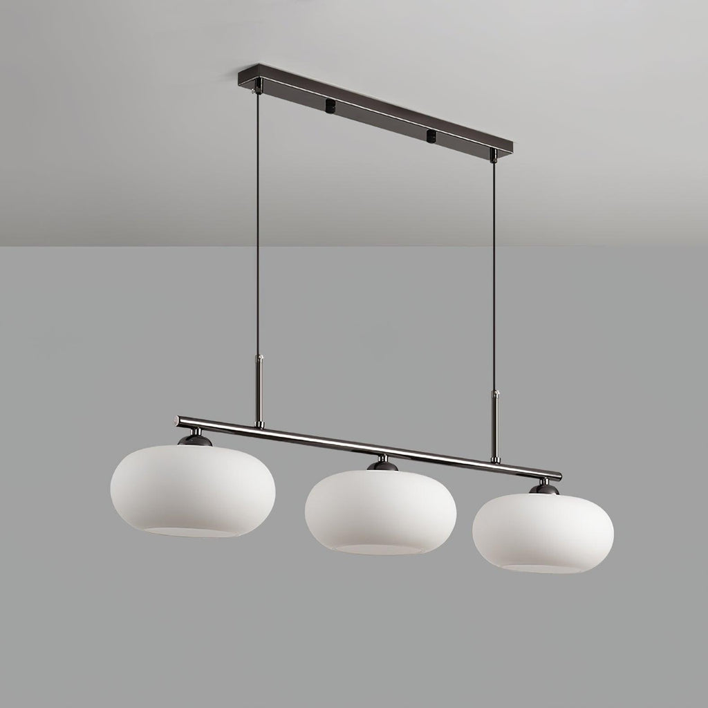 Low-angle studio view of the Clérachic cream glass 3-light cluster on a silver bar, open shade bottoms visible.