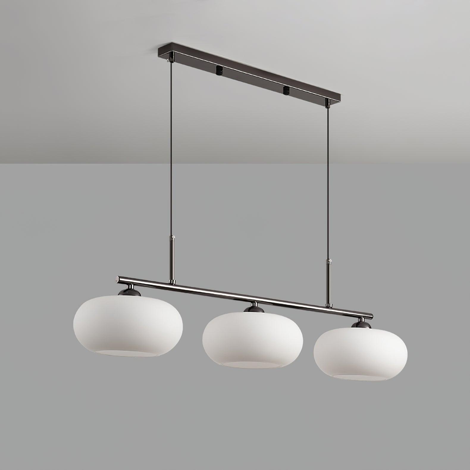 Low-angle studio view of the Clérachic cream glass 3-light cluster on a silver bar, open shade bottoms visible.
