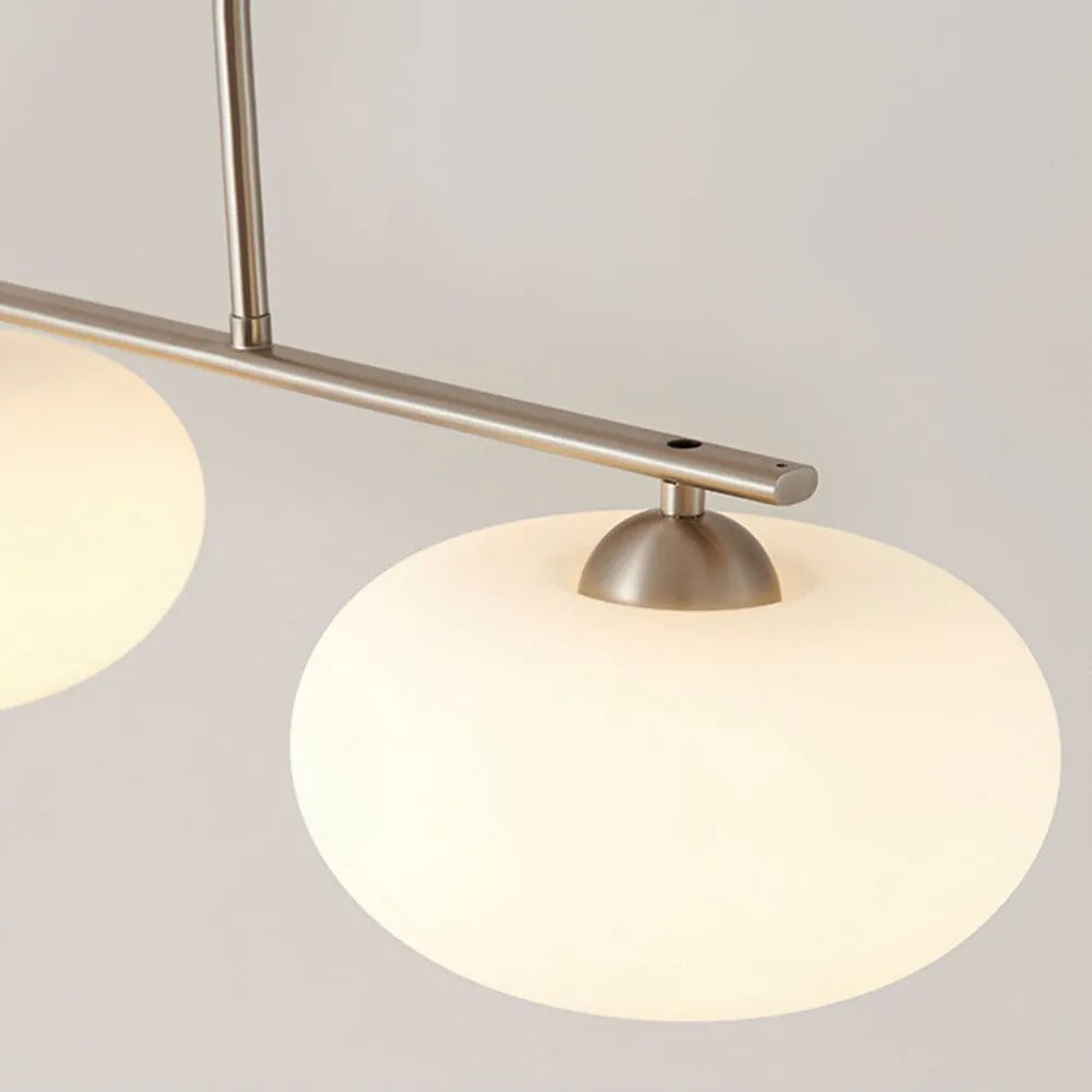 Clérachic silver-frame cream glass pendant, close-up of the bar, vertical rod, and two lit oval shades.