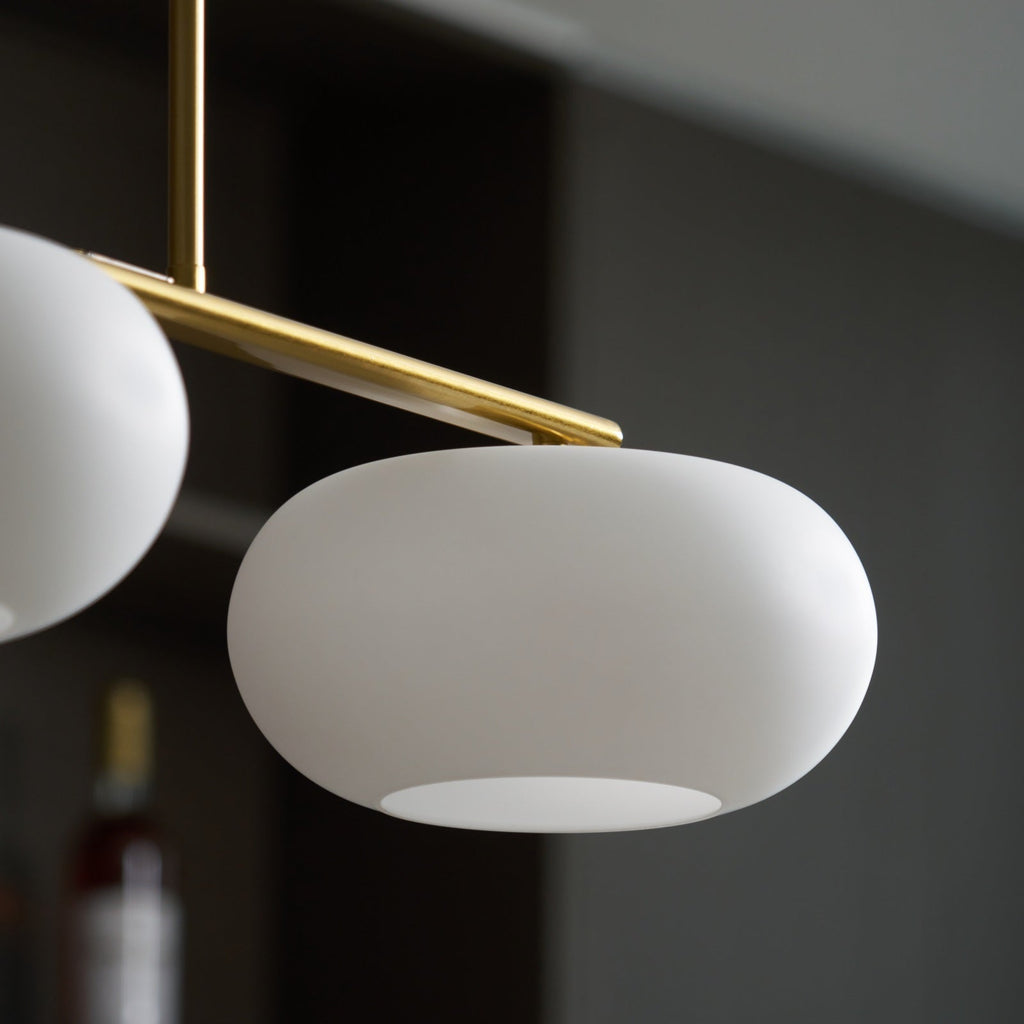 Clérachic gold-frame cream glass cluster, close-up of one shade's open base and a second shade to the left.