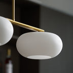 Clérachic gold-frame cream glass cluster, close-up of one shade's open base and a second shade to the left.
