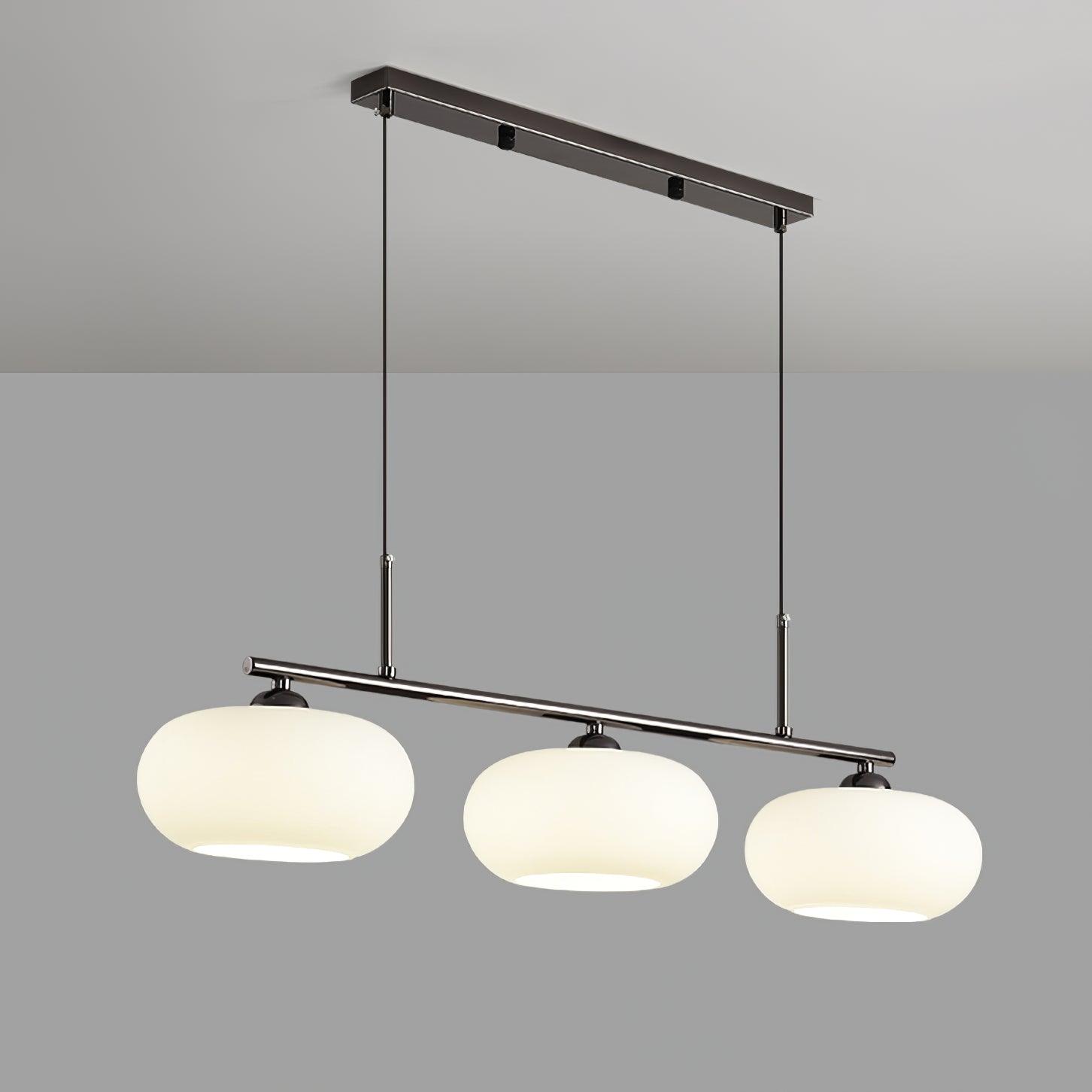 Clérachic cream glass 3-light cluster on a silver canopy and bar, three lit shades against a pale grey wall.