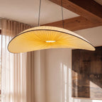Close angle of the Clérachic cream fabric chandelier glowing warm white beneath exposed wood ceiling beams.
