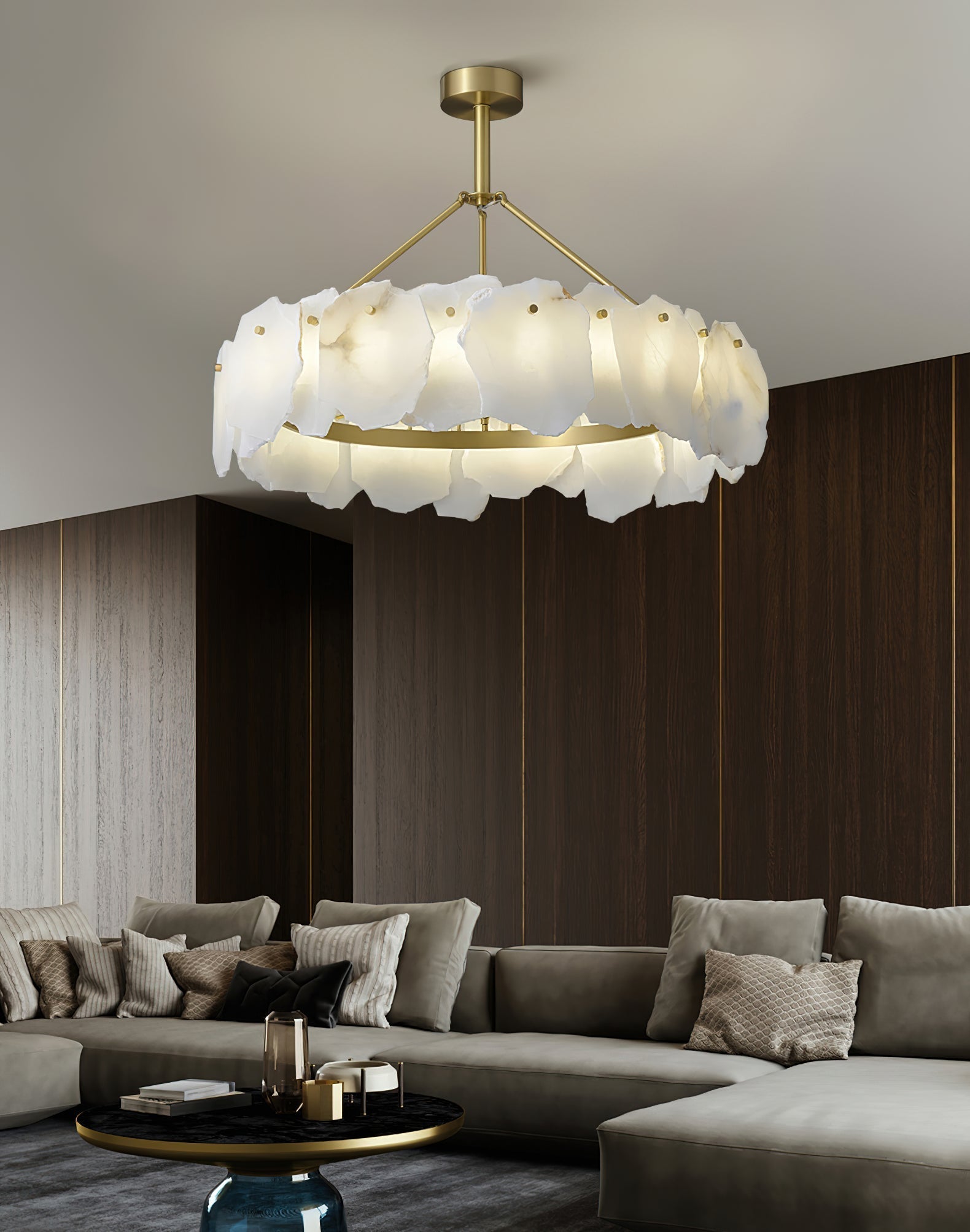 The Clérachic Cryon lit above a grey sectional in a walnut-panelled lounge, its stone ring glowing honey-warm.