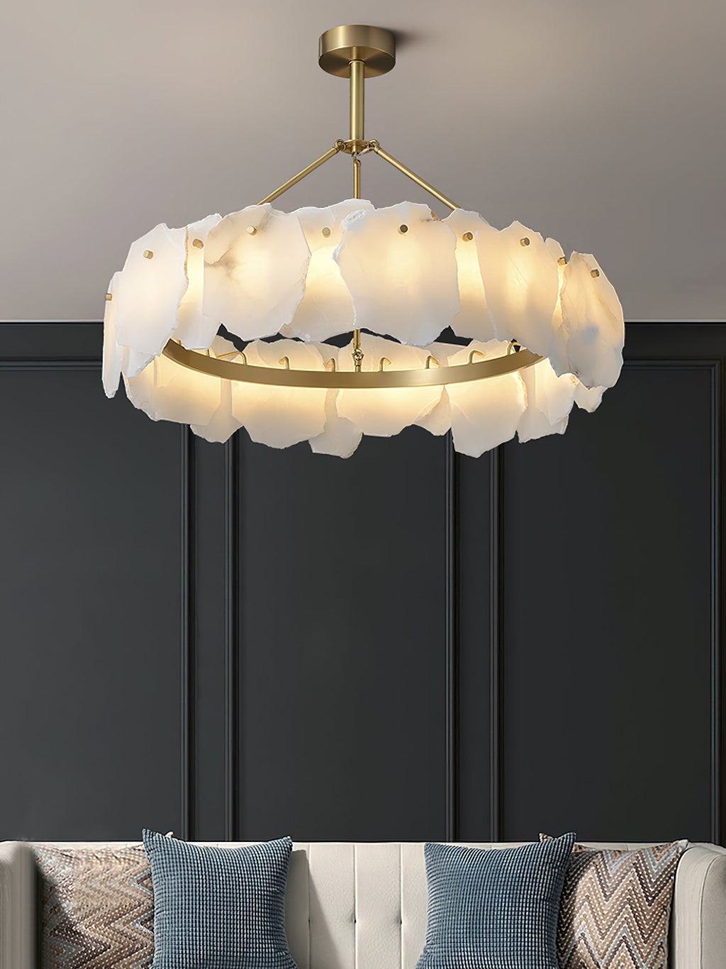 The Clérachic Cryon glowing against a charcoal panelled wall above a cushioned bench and patterned pillows.