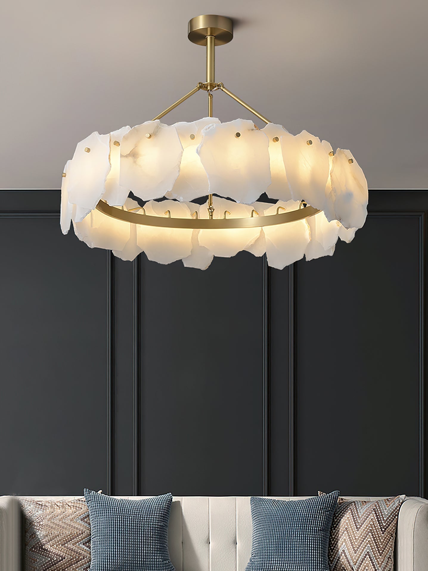 The Clérachic Cryon glowing against a charcoal panelled wall above a cushioned bench and patterned pillows.