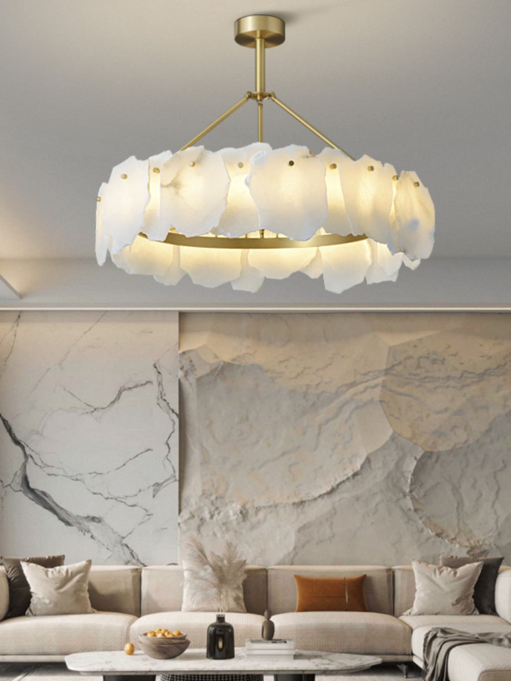 Clérachic Cryon lit in front of a pale stone feature wall, hovering above a cream sofa and low round table.
