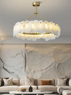 Clérachic Cryon lit in front of a pale stone feature wall, hovering above a cream sofa and low round table.
