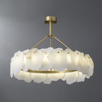 The Clérachic Cryon lit on grey, warm light spilling from the brushed brass band beneath the stone petals.