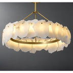 Clérachic Cryon close up and lit, the brushed brass hoop carrying every alabaster plate on small hooked pins.