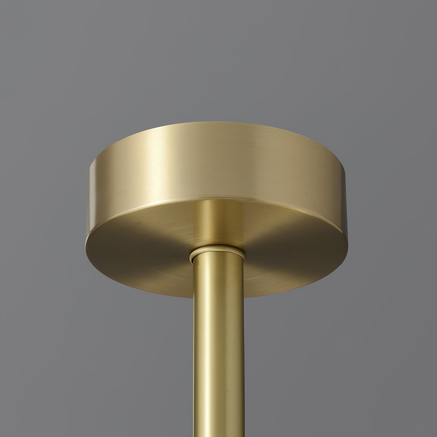 The Clérachic Cryon brass ceiling canopy, a plain machined disc feeding the single central drop rod.