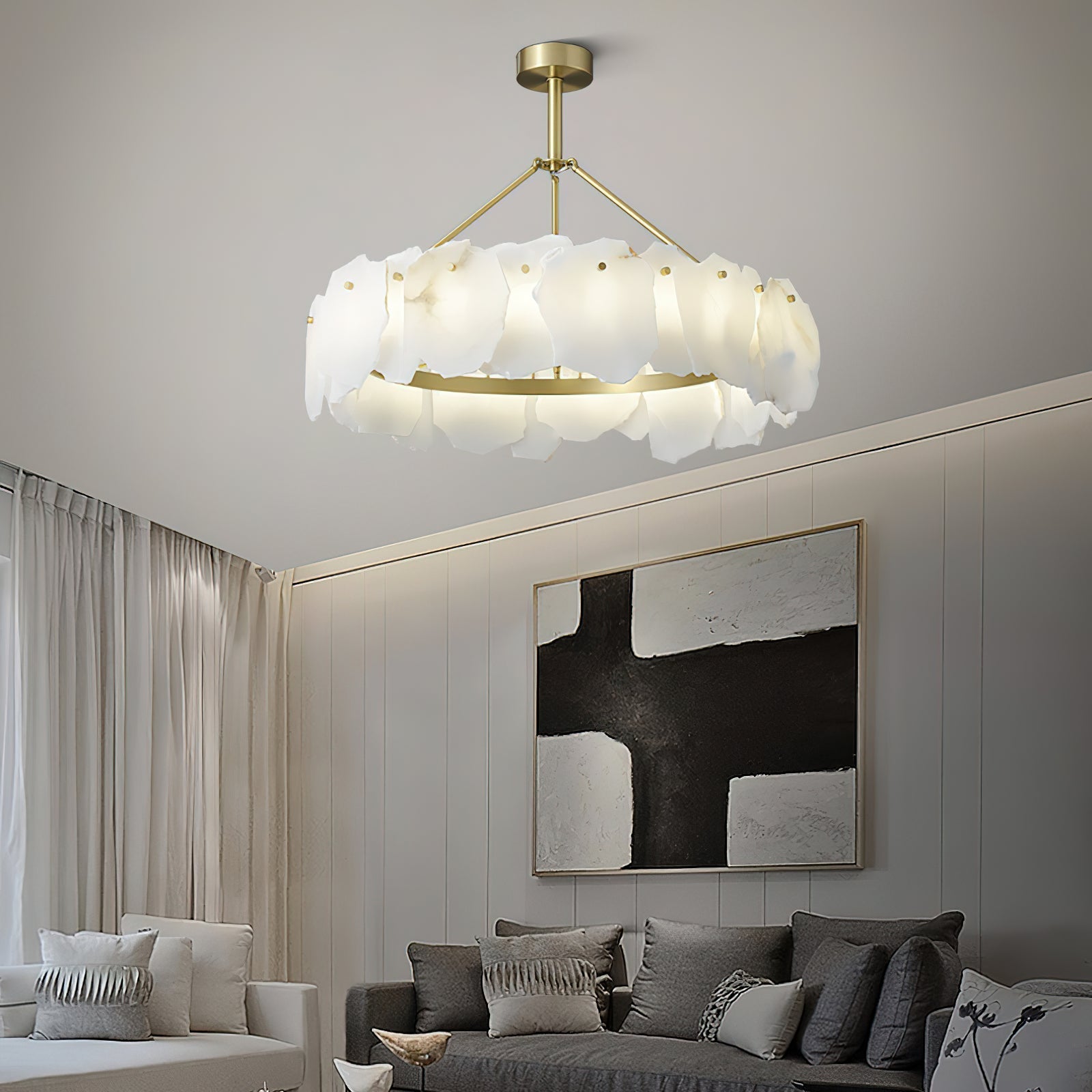 The Clérachic Cryon lit in a pale sitting room, floating above a grey sofa and a black-and-white canvas.