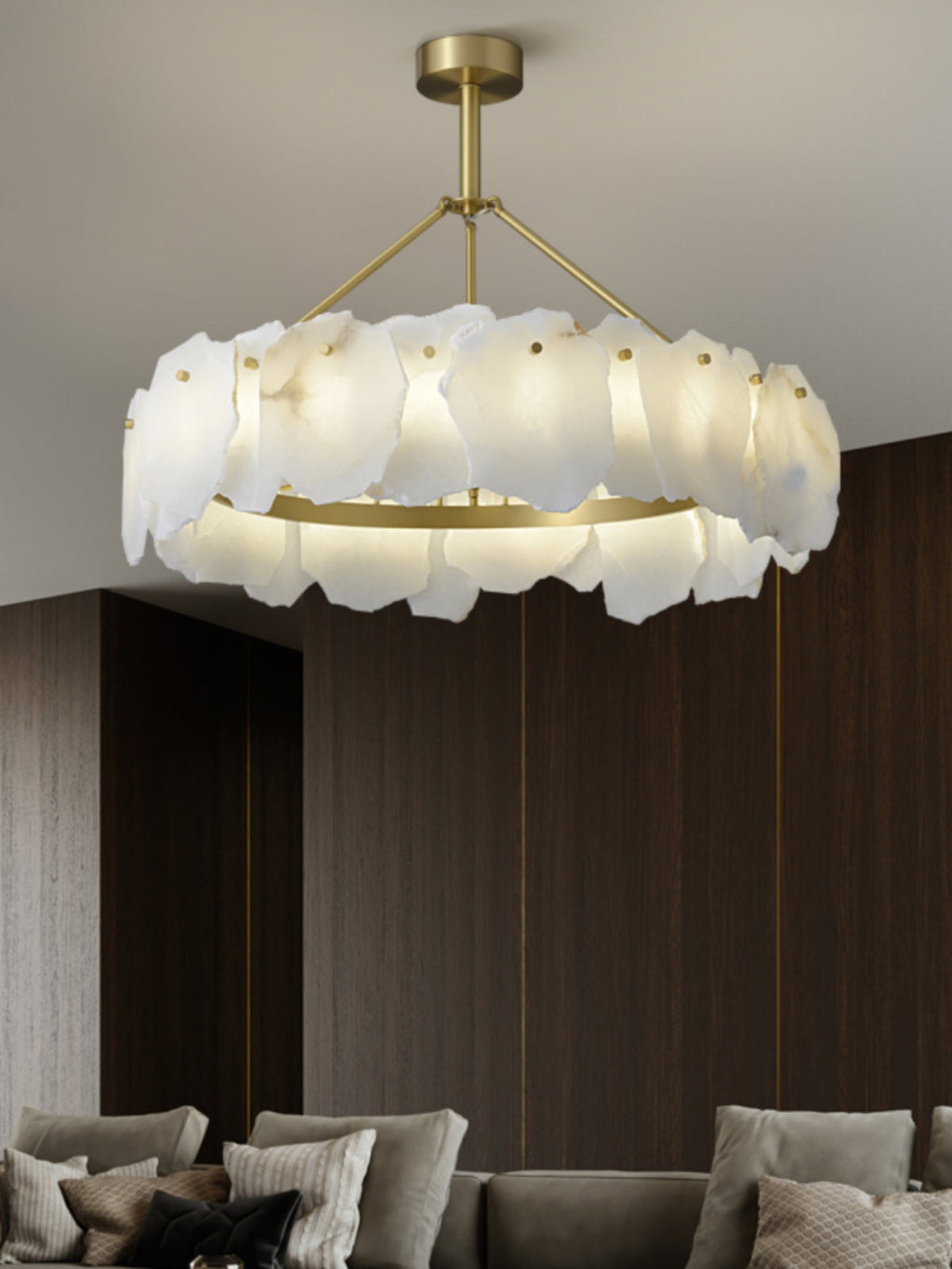 Clérachic Cryon centred over a deep sofa in a dark walnut room, the brass ring throwing light downward.