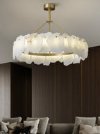 Clérachic Cryon centred over a deep sofa in a dark walnut room, the brass ring throwing light downward.
