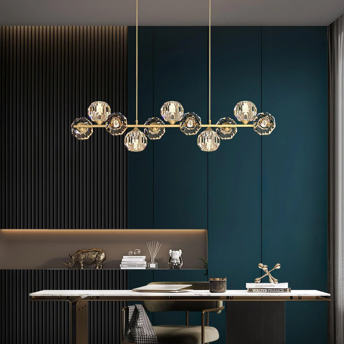 Above a white marble dining table, this Clérachic chandelier shows its brass bar and clear crystal balls against a teal wall.