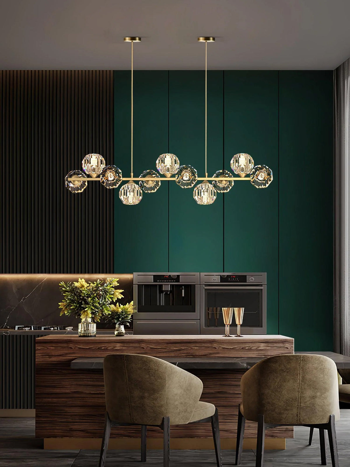 Seen narrower in a green-panelled dining room, a Clérachic crystal chandelier hangs over a wooden table and two olive chairs.