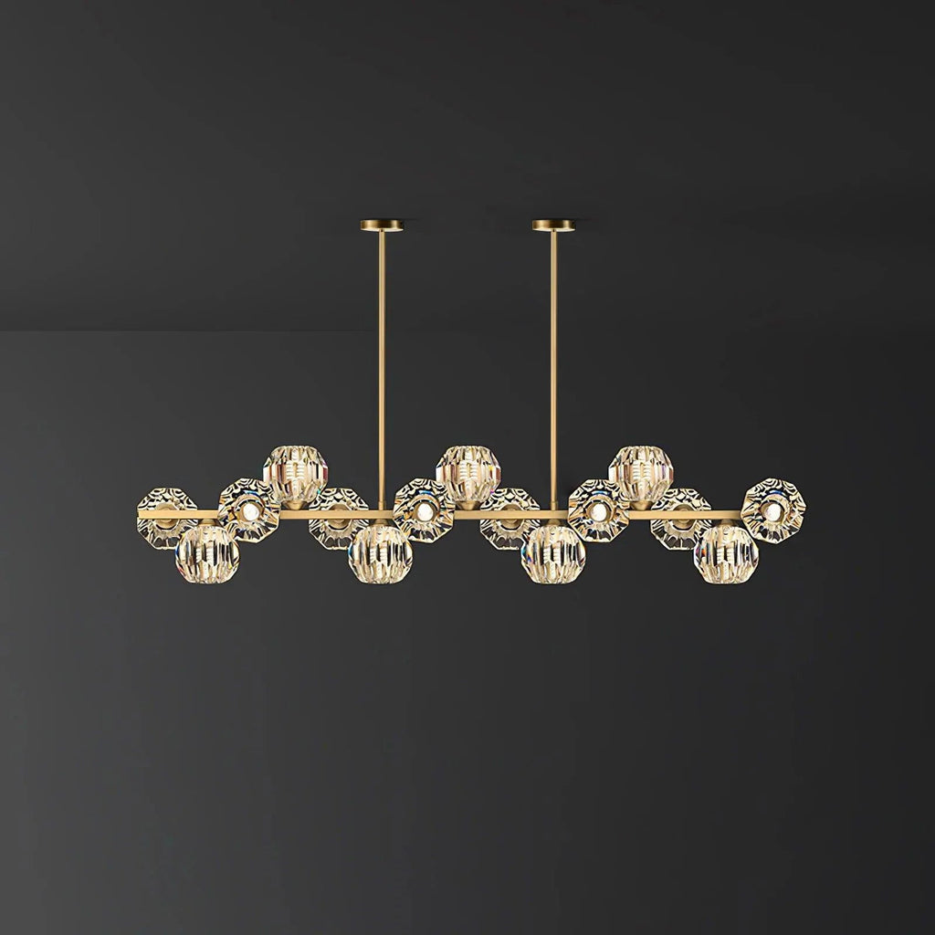 Brass bar with clear crystal balls on a plain charcoal wall, a Clérachic chandelier with two ceiling rods.