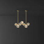 Smaller seven-head version of this Clérachic chandelier on a dark grey backdrop, two brass rods rising to round canopies.