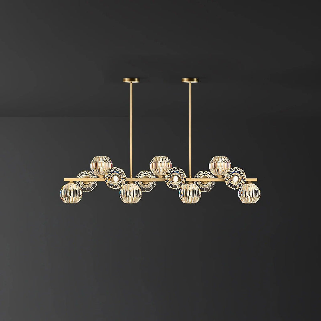Mid-length brass bar with crystal balls and two round ceiling canopies on a dark grey wall, a Clérachic chandelier.