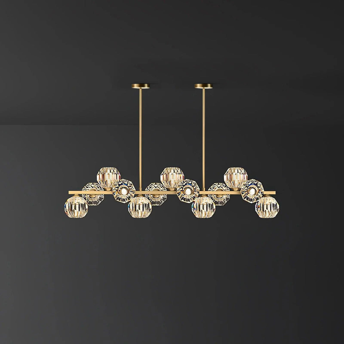 Mid-length brass bar with crystal balls and two round ceiling canopies on a dark grey wall, a Clérachic chandelier.