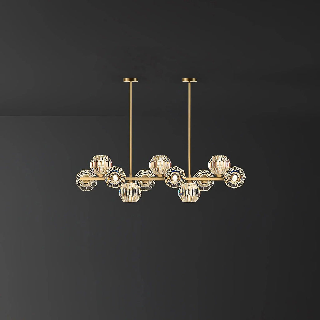 Eleven-head style on a dark backdrop: a brass bar, clear faceted balls and two thin rods from this Clérachic chandelier.