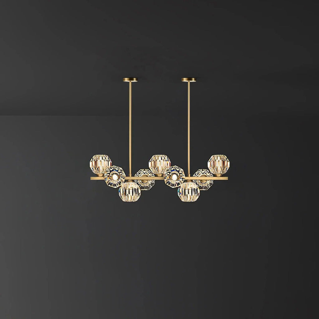Short brass bar with crystal balls and two straight rods against a grey wall, a Clérachic chandelier.