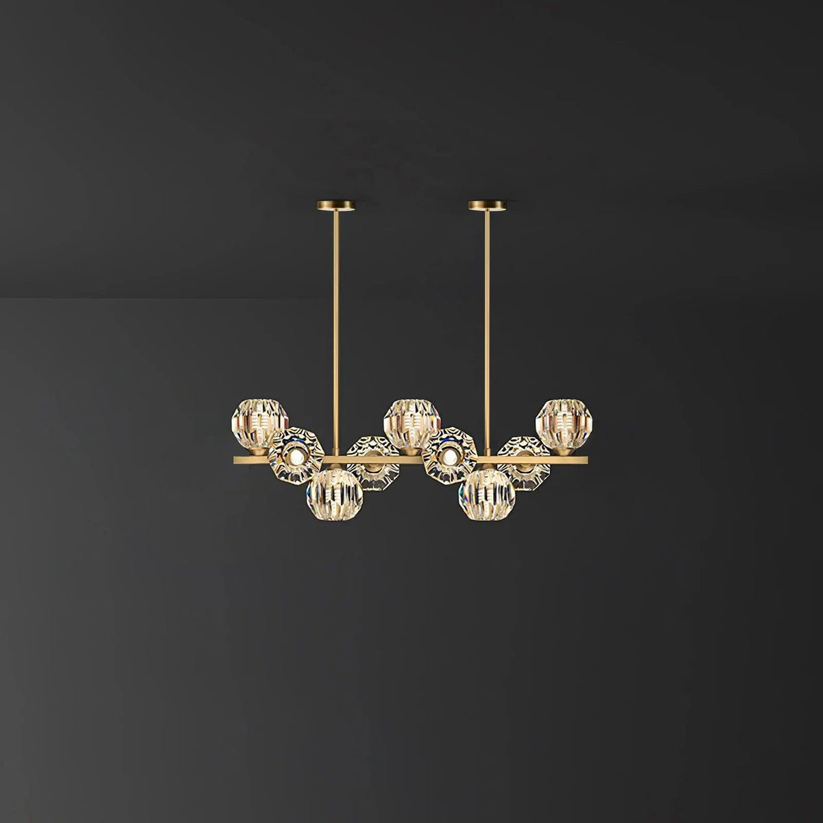 Short brass bar with crystal balls and two straight rods against a grey wall, a Clérachic chandelier.