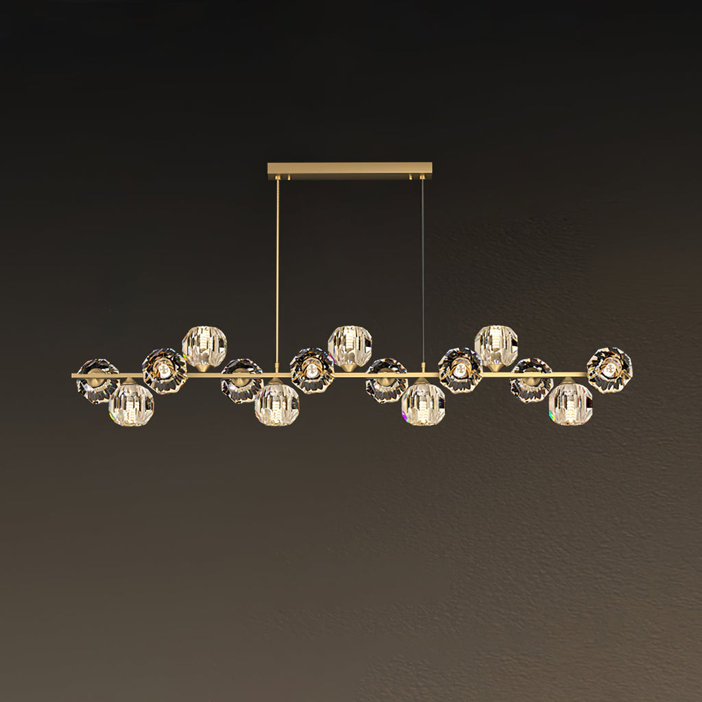 Long brass bar on a rectangular canopy, crystal balls spread evenly, shown on a muted brown wall as a Clérachic chandelier.