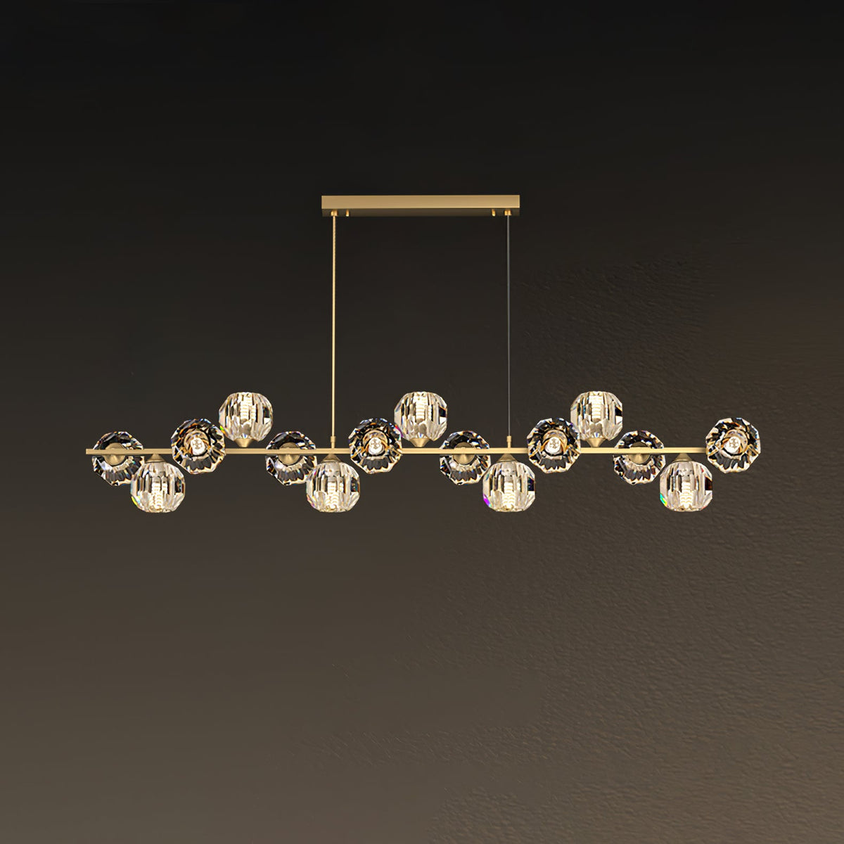 Long brass bar on a rectangular canopy, crystal balls spread evenly, shown on a muted brown wall as a Clérachic chandelier.
