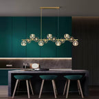 Rectangular canopy and two cords lower a Clérachic chandelier into a teal kitchen with three green bar stools below.