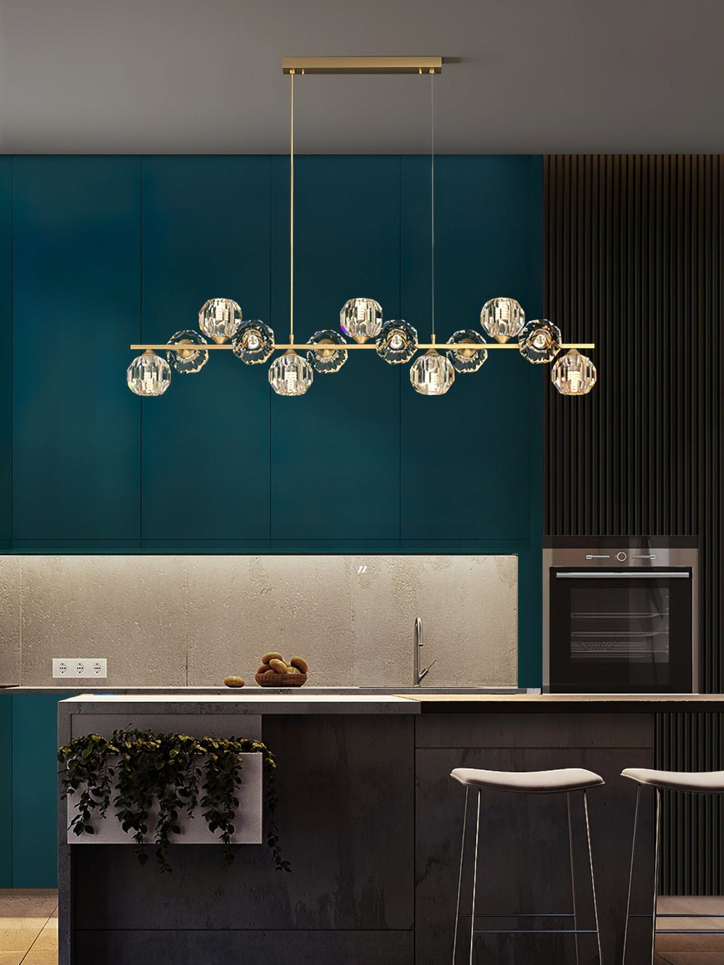 A Clérachic chandelier on a rectangular canopy in a teal kitchen with a stone backsplash, oven and white stools.