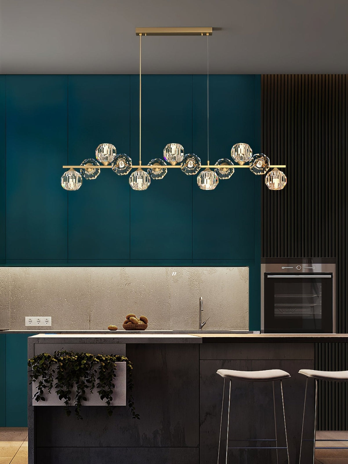 A Clérachic chandelier on a rectangular canopy in a teal kitchen with a stone backsplash, oven and white stools.