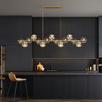 Hung from a rectangular canopy, this Clérachic chandelier spans a charcoal fluted kitchen with a tan bar stool beside it.