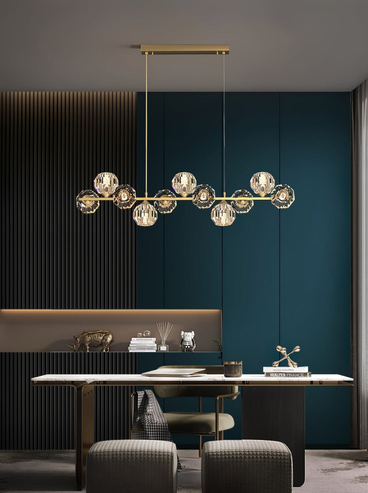 A Clérachic chandelier hangs above a slim white desk in a dark panelled study with teal doors and grey stools.