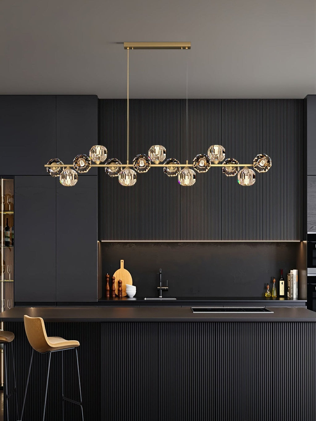 Tall view of a Clérachic chandelier in a dark kitchen, the crystal balls evenly spaced along a brass bar above the island.