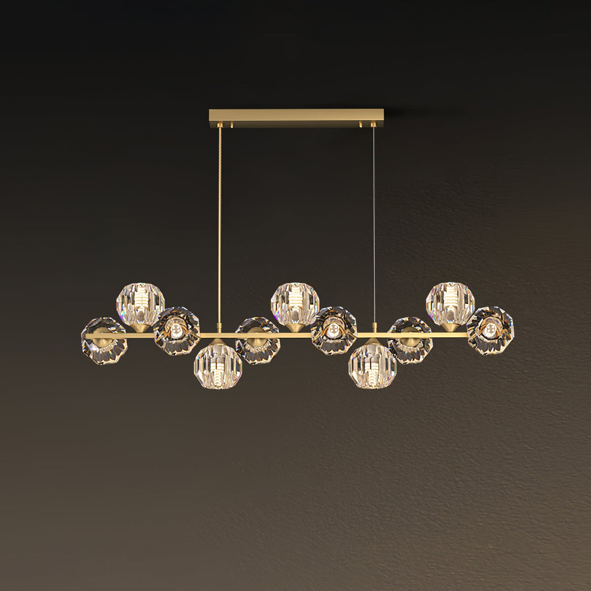 Nine crystal balls along a brass bar, a Clérachic chandelier with a rectangular canopy and two fine cords on a brown backdrop.