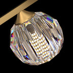Close view of a faceted crystal ball and the cone-shaped brass fitting that joins it to this Clérachic chandelier.
