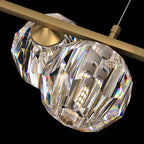 Two crystal balls beneath the flat brass bar, with the hanging cord at the top, on this Clérachic chandelier.