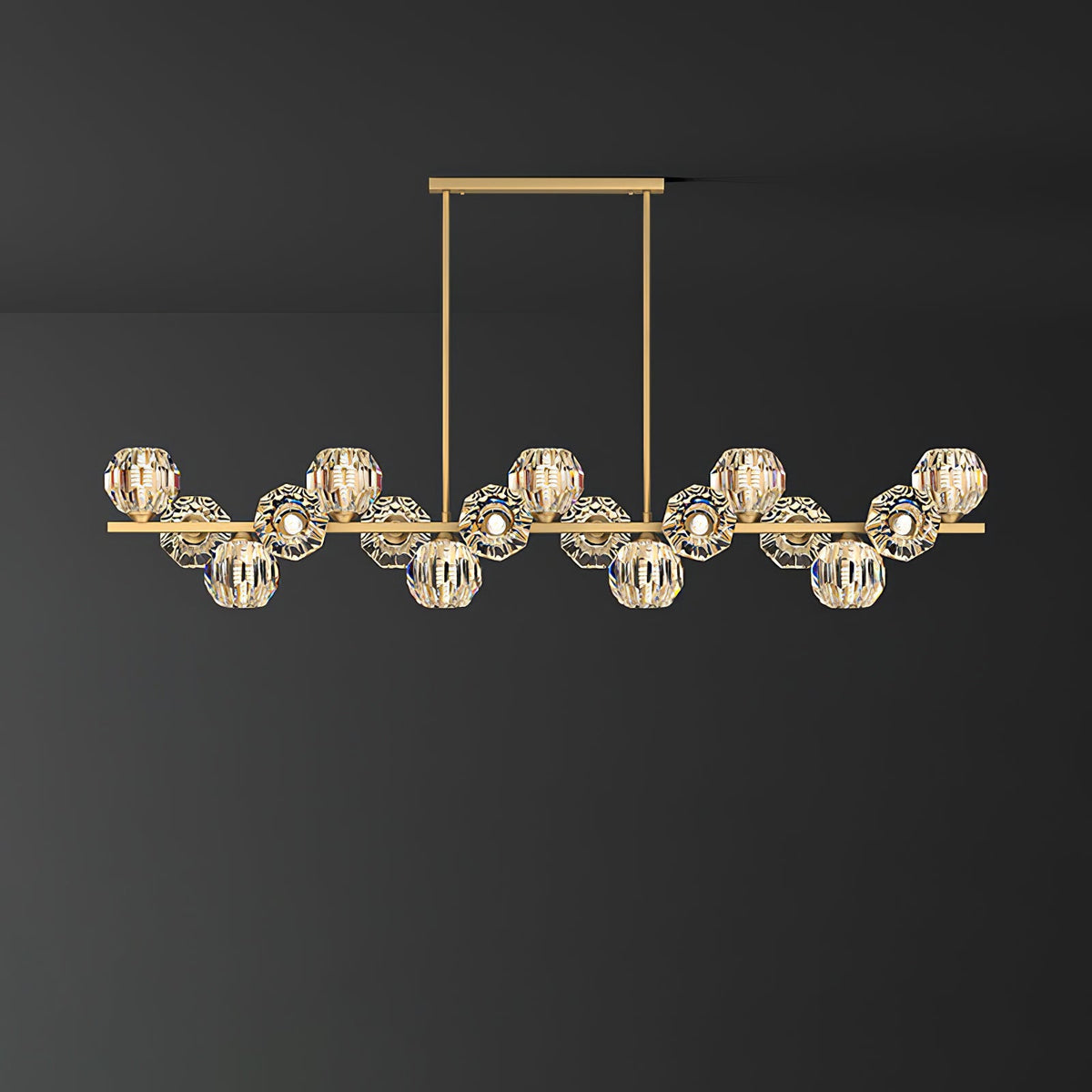 Long brass bar with many clear crystal balls on a rectangular canopy, a Clérachic chandelier against a dark grey wall.