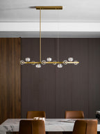 Distant view of a Clérachic chandelier unlit, hung over a marble table with leather chairs against dark wood panelling.
