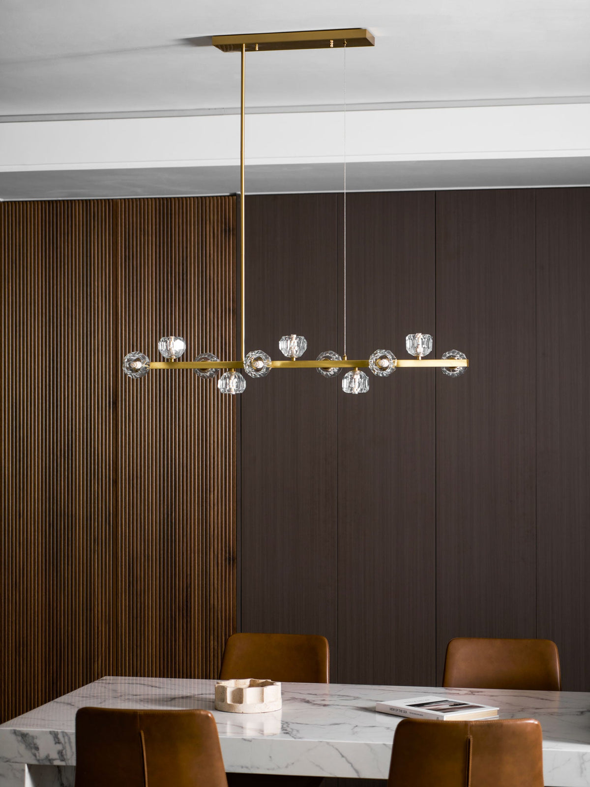 Clérachic chandelier on a rectangular canopy above a marble table, ribbed wood panelling on one side.