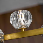 Underside view of a single faceted crystal ball on its brass stem, part of this Clérachic chandelier.
