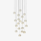 Clérachic crystal ball pendant light with clear glass spheres on fine cables at staggered heights, on a plain white backdrop.